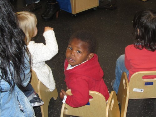 Little one listening to reading a St. Vincent De Paul Village, Child Development Center.